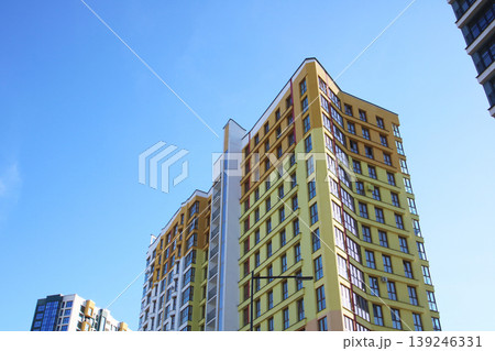 A tall building stands prominently against a blue sky backdrop 139246331