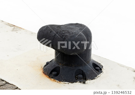 Black cast-iron mooring bollard mounted on a concrete pier 139246532