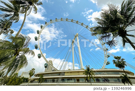 The giant Singapore Flyer Ferris wheel against a bright blue sky in the Marina Bay area, an iconic landmark The giant Singapore Flyer Ferris wheel against a bright blue sky in the Marina Bay area, an iconic landmark 139246996