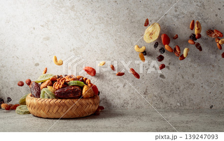 Mix of dried fruits and nuts in motion on a gray background. Mix of dried fruits and nuts in motion on a gray background. 139247093