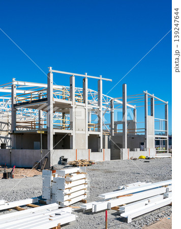 Steel beams and concrete columns forming industrial building structure at construction site 139247644