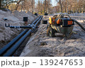 Underground insulated utility pipeline installation with dewatering equipment in construction trench 139247653
