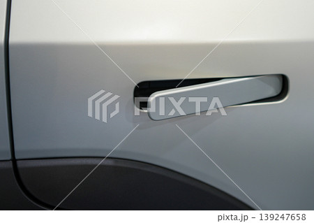 Modern white electric car door handle close-up with flush design and sleek automotive detail 139247658