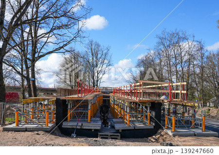 Bridge under construction with scaffolding support structure and safety rails under blue sky Bridge under construction with scaffolding support structure and safety rails under blue sky 139247660