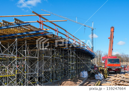 Overpass bridge construction with scaffolding and mobile crane at large infrastructure project site 139247664