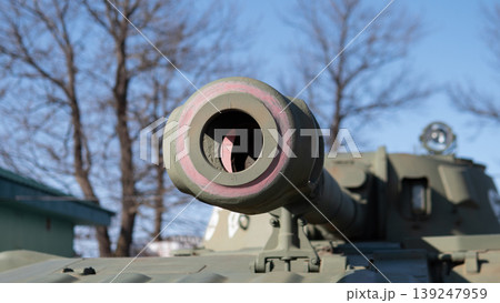 Closeup Tank Barrel Muzzle Facing Clear Sky, Chipped Green Paint And Textured Steel, Museum Outdoor Exhibit With Bare Trees And Cold Winter Light, Close Framing Emphasizes Heavy Armor Closeup Tank Barrel Muzzle Facing Clear Sky, Chipped Green Paint And Textured Steel, Museum Outdoor Exhibit With Bare Trees And Cold Winter Light, Close Framing Emphasizes Heavy Armor 139247959