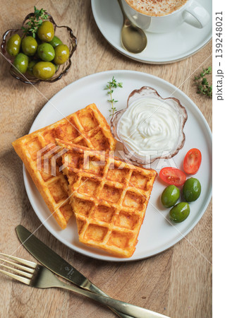 Crunchy waffle fries with sour cream dip served in a basket 139248021