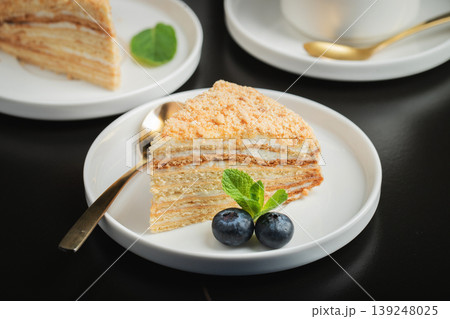 Medovik. Honey cake made from honey cakes with whipped sour cream, decorated with berries, pomegranate and flowers 139248025