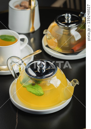 Fruit tea with mango and mint in a glass teapot on the table 139248027