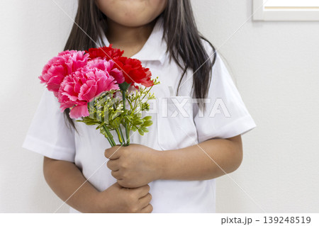 造花の赤いカーネーションを持った女の子(5歳、日本人、顔無し) 造花の赤いカーネーションを持った女の子(5歳、日本人、顔無し) 139248519