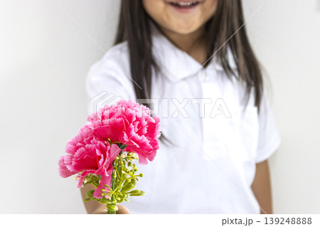 造花の赤いカーネーションを渡す女の子(5歳、日本人、顔無し) 造花の赤いカーネーションを渡す女の子(5歳、日本人、顔無し) 139248888