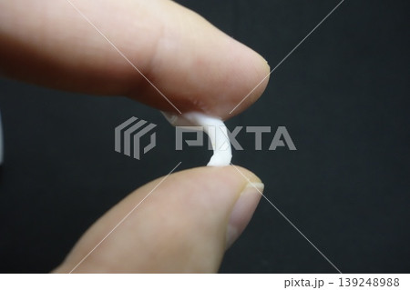 Fingers Holding Small White Object Close-Up 139248988