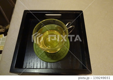Glass Cup with Yellow Liquid on Tray Glass Cup with Yellow Liquid on Tray 139249031
