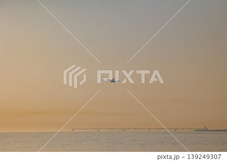 羽田空港の夕焼け空と遠くにポツンと浮かぶ飛行機のシルエット 羽田空港の夕焼け空と遠くにポツンと浮かぶ飛行機のシルエット 139249307