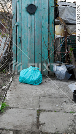 turquoise bag on concrete near an old shed door turquoise bag on concrete near an old shed door 139249576