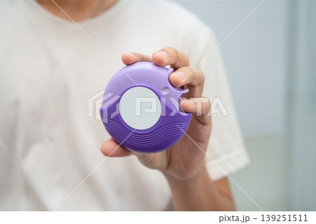 Asthma and chronic obstructive pulmonary disease COPD, Asian young man using metered dose inhaler MDI. Asthma and chronic obstructive pulmonary disease COPD, Asian young man using metered dose inhaler MDI. 139251511
