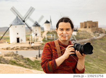 Woman tourist takes pictures of the windmills of city of Consuegra. Spain Woman tourist takes pictures of the windmills of city of Consuegra. Spain 139251758