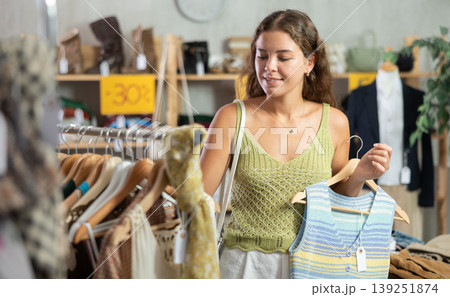 Young woman choosing vest in clothing store Young woman choosing vest in clothing store 139251874