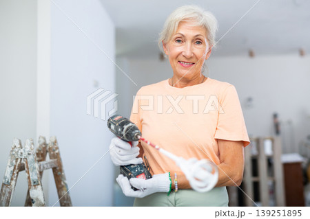Mature woman posing with home renovation tools Mature woman posing with home renovation tools 139251895