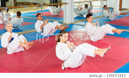 Athletes man and woman in kimono doing abdominal exercise in gym 139251915