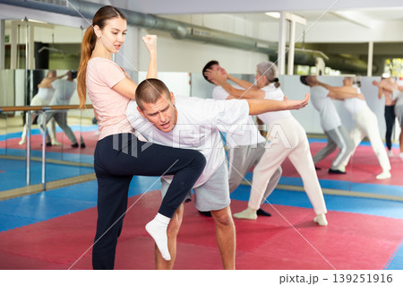 Woman learning knee strike move during self-defense training Woman learning knee strike move during self-defense training 139251916