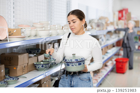 Girl customer chooses soup tureen with Asian style 139251983