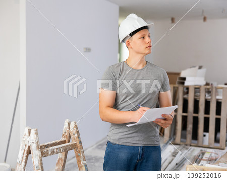 Young man checking project documentation in apartment during repair works 139252016
