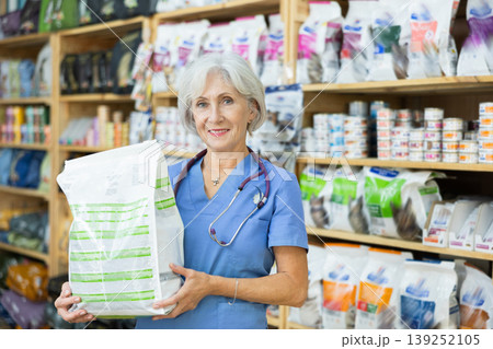 Smiling female veterinarian holding bag with healthy dry pet food 139252105