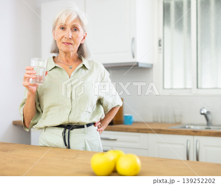 Smiling mature woman with glass of water Smiling mature woman with glass of water 139252202