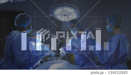 Operating surgical team wearing blue scrubs performing surgery at OR table, with chart overlay Operating surgical team wearing blue scrubs performing surgery at OR table, with chart overlay 139252885
