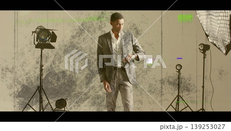 Glancing mid-adult model in grey suit checking wristwatch in studio, with studio lights Glancing mid-adult model in grey suit checking wristwatch in studio, with studio lights 139253027