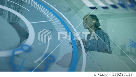 Scrub-clad nurse checking patient vital signs in ward, with tablet, digital projection, copy space 139253118