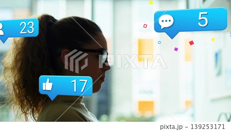 Monitoring woman with glasses turtleneck sitting in office, with notification icons, copy space Monitoring woman with glasses turtleneck sitting in office, with notification icons, copy space 139253171