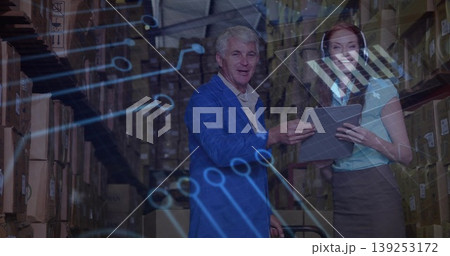 Reviewing warehouse professionals consulting tablet in warehouse aisle, showing holographic overlay 139253172