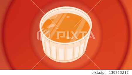 Displaying white ceramic ramekin holding orange liquid on red concentric backdrop, with reflections 139253212