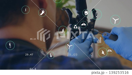Mechanic wearing blue gloves tightening brake cable on handlebar at workshop bench, with IoT icons Mechanic wearing blue gloves tightening brake cable on handlebar at workshop bench, with IoT icons 139253516
