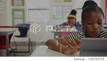Using tablet girl wearing striped shirt with braided hair sitting at school desk, natural daylight Using tablet girl wearing striped shirt with braided hair sitting at school desk, natural daylight 139253570