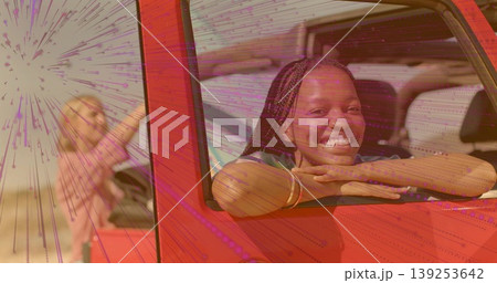 Leaning women smiling through red off-road vehicle windows on sandy plain, bracelets, copy space Leaning women smiling through red off-road vehicle windows on sandy plain, bracelets, copy space 139253642