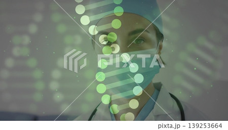 Displaying female medic analyzing DNA helix overlay in lab, with stethoscope mask cap lab coat Displaying female medic analyzing DNA helix overlay in lab, with stethoscope mask cap lab coat 139253664