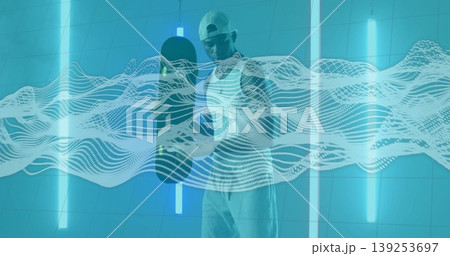 Man wearing cap holding skateboard vertically in futuristic studio, with neon tubes, wave overlay Man wearing cap holding skateboard vertically in futuristic studio, with neon tubes, wave overlay 139253697