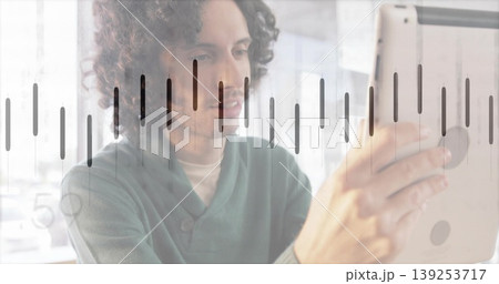 Reviewing male professional wearing green sweater holding tablet in office, with equalizer overlay Reviewing male professional wearing green sweater holding tablet in office, with equalizer overlay 139253717