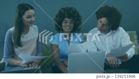 Discussing team sharing printed documents and laptop on modern office lounge sofa, with cushions Discussing team sharing printed documents and laptop on modern office lounge sofa, with cushions 139253986