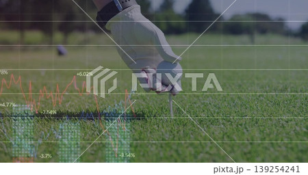 Placing golf ball on tee at golf course, with gloved hand wearing wristwatch and data overlay 139254241