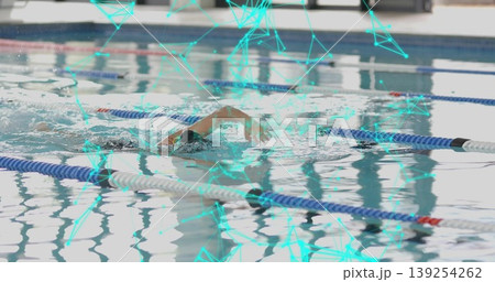 Gliding swimmer in cap goggles cutting through facility pool with teal network overlay lane ropes Gliding swimmer in cap goggles cutting through facility pool with teal network overlay lane ropes 139254262