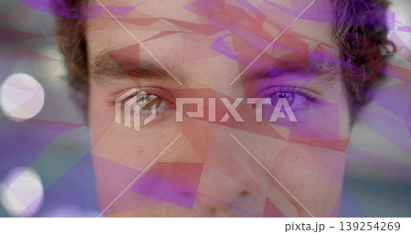Displaying adult male face overlaid with purple geometric shapes in studio, with circular lights 139254269