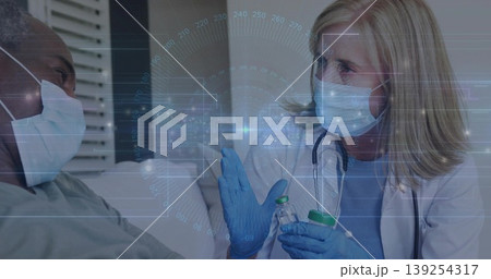 clinician holding two vials wearing gloves speaking to masked patient in exam room, data overlay 139254317