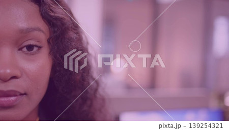 Facing camera, woman in yellow top at desk, screen blur, pastel lights, copy space 139254321