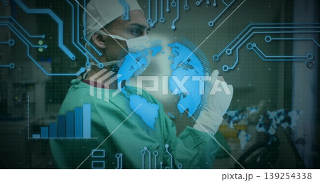 Interacting surgeon wearing scrubs analyzing globe, digital interface and chart in OR, copy space 139254338