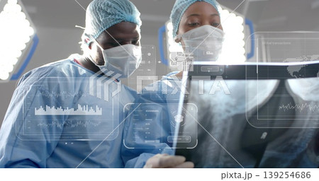 Surgeons displaying hip X-ray and tapping holographic charts and vitals for surgery planning 139254686