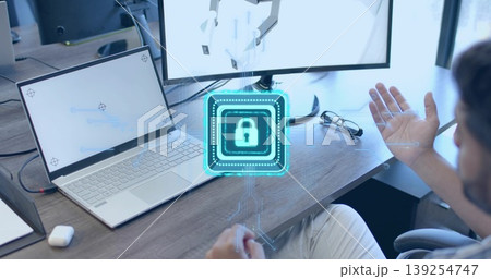 Gesturing man in shirt touching holographic lock icon above desk, with laptop, monitor, copy space Gesturing man in shirt touching holographic lock icon above desk, with laptop, monitor, copy space 139254747